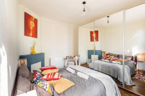 una camera da letto con due letti e uno specchio di Oasis urbain a Saint-Maur-des-Fossés