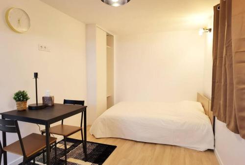 a bedroom with a bed and a desk with a table at New renoveted studio in calm area near nation in Paris
