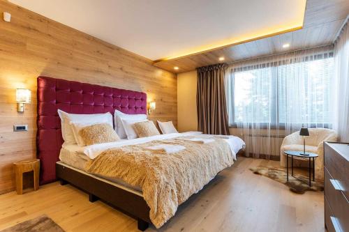 een slaapkamer met een groot bed met een rood hoofdeinde bij Villa 1331 in Zheleznitsa