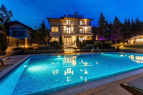 een zwembad voor een huis 's nachts bij Villa 1331 in Zheleznitsa