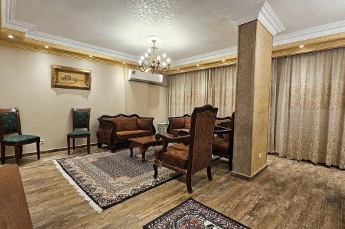 a living room with a couch and a table and chairs at Comfy 2 Bedrooms Apartment in Cairo 92 in Cairo
