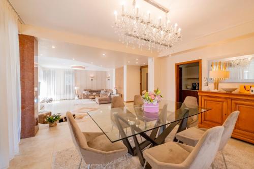 comedor y sala de estar con mesa de cristal y sillas en Villa 1331, en Zheleznitsa