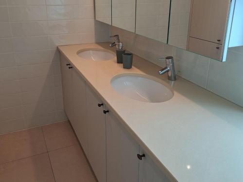 une salle de bain avec deux lavabos et un miroir dans l'établissement Happy wim', à Wimereux