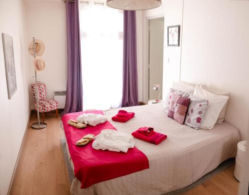 - une chambre avec un grand lit et des serviettes rouges dans l'établissement Le Cosy du Gal, à 2 Pas du Palais des Papes parking gratuit securisé, à Avignon