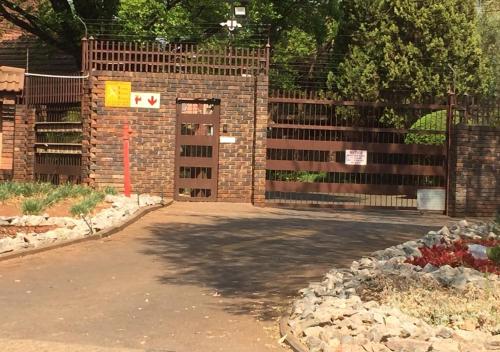 a brick fence with a gate and a driveway at Entire Apartment in Eldoraigne, Centurion in Eldoraigne