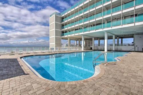a large swimming pool in front of a building at COUPLES GETAWAY, HONEYMOON SWEET, Perfectly Cozy Beach Front Condo with kitchen, pool, free parking,CHECK-IN AT DOOR in Panama City Beach