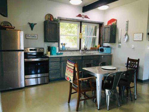 a kitchen with a table and chairs and a refrigerator at Longhorn Cabin near Hidden Falls with View in Smithwick
