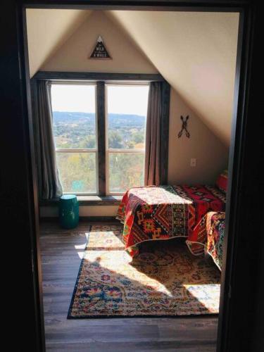a room with two beds and a large window at Longhorn Cabin near Hidden Falls with View in Smithwick