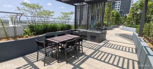 a patio with a table and chairs on a balcony at Temuan Mayabay at Splashmania Gamuda Cove in Banting