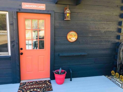 a red door on the side of a house at Longhorn Cabin near Hidden Falls with View in Smithwick