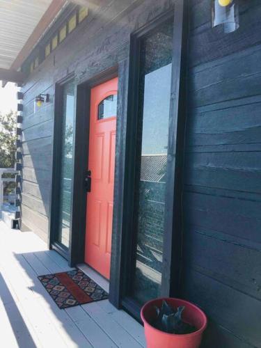 a red door on the side of a house at Longhorn Cabin near Hidden Falls with View in Smithwick