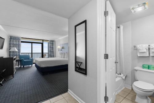 a bathroom with a toilet and a bedroom with a bed at Grande Shores in Myrtle Beach