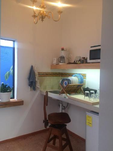 a kitchen with a counter and a chair in a room at Casa Molcajete in Mexico City