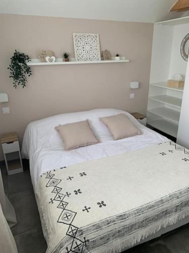 - une chambre avec un lit blanc et des oreillers dans l'établissement Logement T2 indépendant 10 mn Angers, à Brain-sur-lʼAuthion