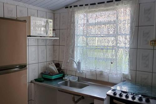a kitchen with a sink and a window at Recanto massaguaçu in Massaguassu