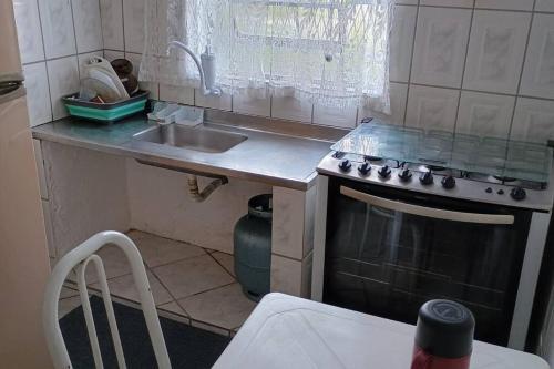 a small kitchen with a sink and a stove at Recanto massaguaçu in Massaguassu