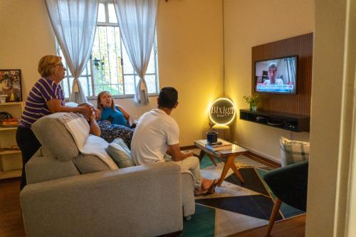 a group of people sitting in a living room watching tv at Bixiga Hostel in Sao Paulo