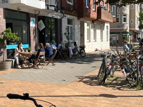 a group of people sitting at tables on a city street at Kiel zwischen Blücherplatz und Forstbaumschule 2 oder 3 Zimmer Ferienwohnung in Kiel