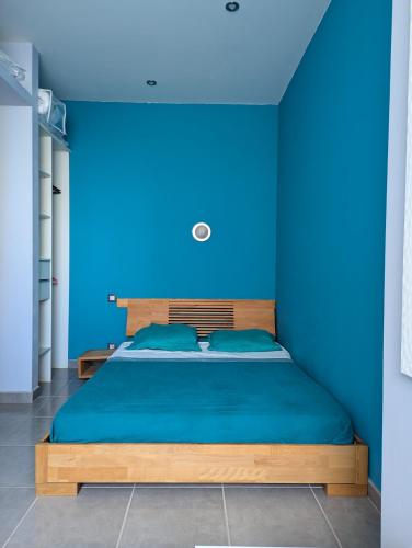 - une chambre bleue avec un lit aux murs bleus dans l'établissement Ti Caraïbe appartement vue mer et parking gratuit du 1 juin au 30 septembre, à Canet