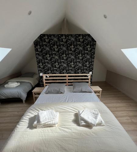 une chambre avec deux lits dans un grenier dans l'établissement L antre du stade, à Lens