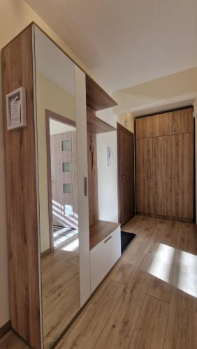 an empty room with a mirror and wooden doors at Apart Harmony in Ruse