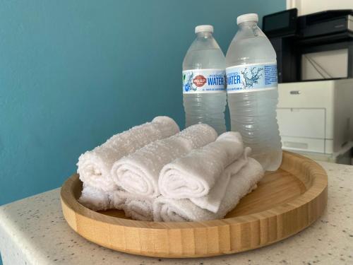 una pila di asciugamani e due bottiglie d'acqua di Melrose Beach Apartments Inc a Bridgetown