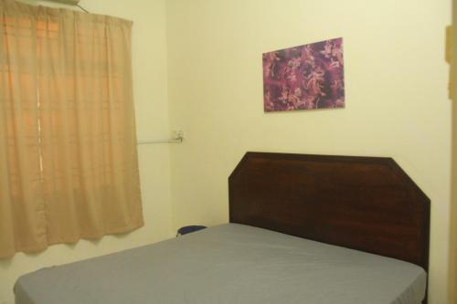 a bedroom with a bed and a picture on the wall at kluang homestay villa 1 in Kluang