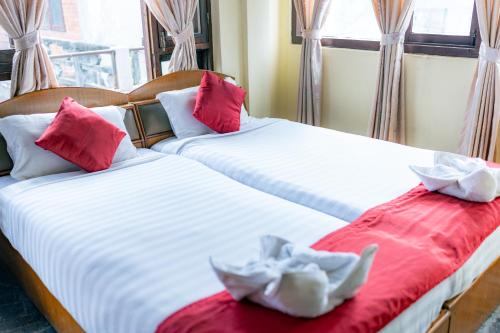 two beds in a room with red and white sheets at Golden Gate Guest House in Bhaktapur
