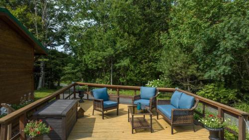 a deck with blue chairs and a table at Cosy Lake Paradise 4-Bed Retreat Pet Friendly in Rothesay
