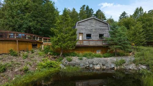an old house sitting next to a body of water at Cosy Lake Paradise 4-Bed Retreat Pet Friendly in Rothesay