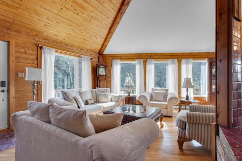 a living room with couches and tables and windows at Cosy Lake Paradise 4-Bed Retreat Pet Friendly in Rothesay