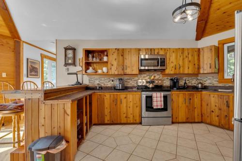 a large kitchen with wooden cabinets and appliances at Cosy Lake Paradise 4-Bed Retreat Pet Friendly in Rothesay