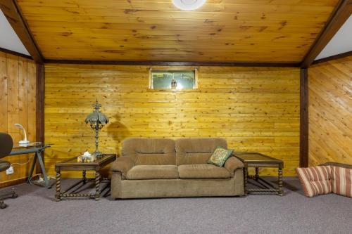a living room with a couch and wooden walls at Cosy Lake Paradise 4-Bed Retreat Pet Friendly in Rothesay