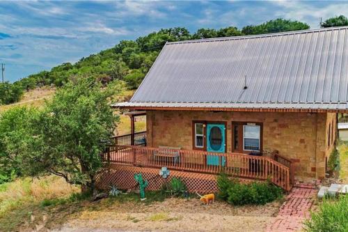 a small brick house with a metal roof at RUSTIC BLUEBONNET CABIN With VIEW BY HIDDEN FALL PARK in Marble Falls