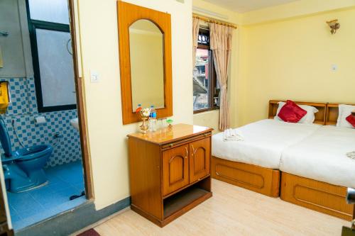 a bedroom with a bed and a bathroom with a shower at Golden Gate Guest House in Bhaktapur