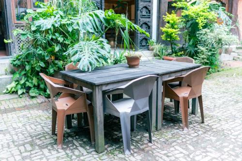 a wooden table and chairs in a garden at Golden Gate Guest House in Bhaktapur