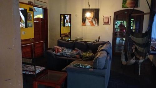 a living room with a couch with pillows on it at Casa Calhetas Pousada I in São Sebastião