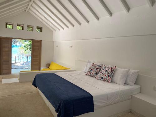 a white bedroom with a bed with pillows on it at Casa Rosario in Isla Grande