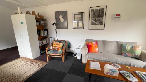 a living room with a couch and a table at @Taradise-Opunake - eco-friendly Coastal hideaway in Opunake