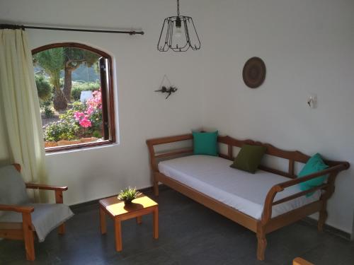 a room with a bed and a window and a chair at Porto Heli Apartments in Palekastron