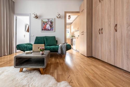 a living room with a green couch and a table at Top Location & Style Vespa Apt in the Heart of Sofia in Sofia