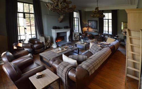 a living room with leather furniture and a fireplace at Chateau Beausaint in La-Roche-en-Ardenne