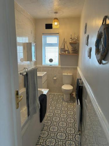 a bathroom with a toilet and a sink at Victoria Beach Cottage in Prestatyn