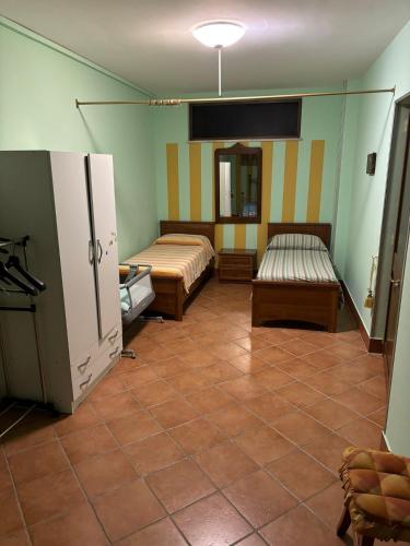 a room with two beds and a tiled floor at B&b Villa Candida in San Felice a Cancello