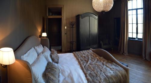 a bedroom with a bed with two cats laying on it at Chateau Beausaint in La-Roche-en-Ardenne