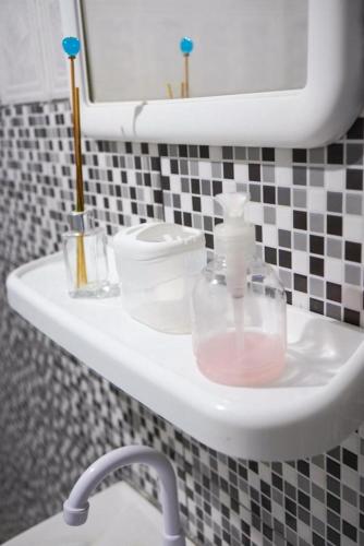 a bathroom sink with a bottle of soap on it at Casa de praia DM in Luis Correia