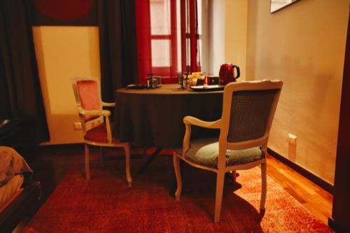 a room with two chairs and a table in a room at Le Cœur Urban Suite Parma in Parma