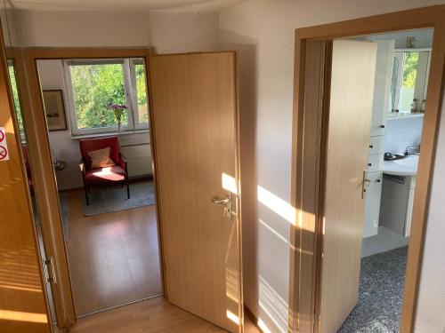 a hallway with a door and a chair in a room at Privatzimmer am Volkspark - Nähe Arenen und Trabrennbahn in Hamburg
