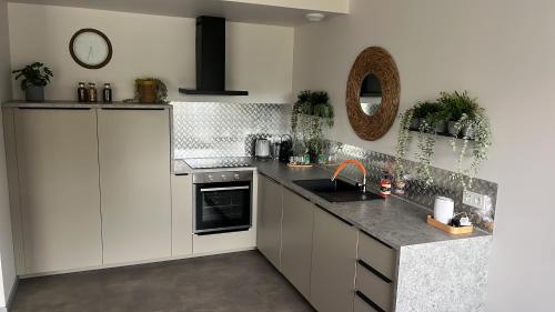 a kitchen with white cabinets and a sink at Près colmar 6 in Wolfgantzen