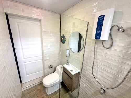 a bathroom with a toilet and a sink and a shower at Jungla Urbana, BnB in Pavas